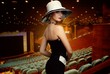 Woman in white hat in theatre interior