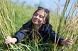 Foto: Woman in sunglasses looks through the grass with ears Woman in sunglasses looks through the grass with ears