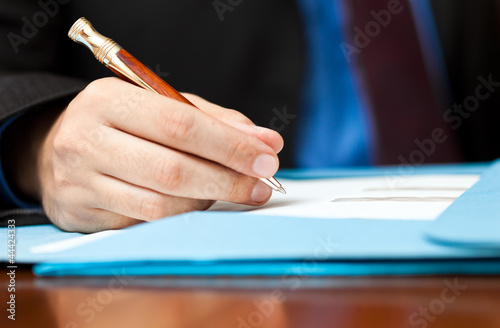 Foto: Businessman writing a document in his office Businessman writing a document in his office