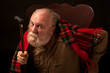 Old man scowls, leans forward and shakes his cane
