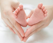 newborn baby feet on female hands