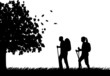 Hiking couple with rucksacks in autumn or fall silhouette