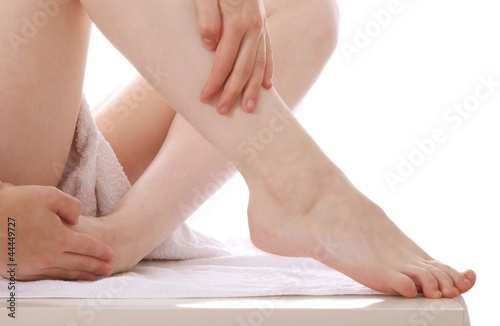 Photo: Woman massaging legs (white background) Woman massaging legs (white background)
