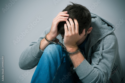 Photo: Arrested teenager with handcuffs on his hands Arrested teenager with handcuffs on his hands