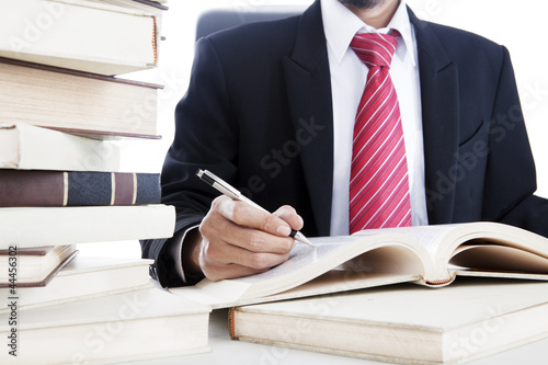 Photo: Businessman writes on a book Businessman writes on a book
