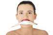 Beautiful young woman with fish in her mouth
