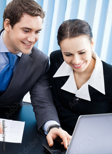 Photo: Businesspeople working with laptop at office Businesspeople working with laptop at office