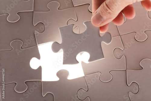 Photo: hand holding puzzle piece hand holding puzzle piece