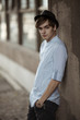 Handsome man casually leaning against the wall