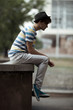 Handsome man sitting on the curb in city