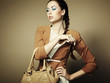 Portrait of beautiful young woman with a leather bag