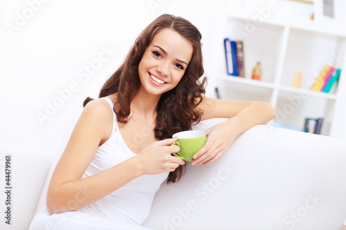 Foto: Young pretty woman in white at home Young pretty woman in white at home