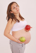 Photo: Pregnant woman holding apples in the hands of Pregnant woman holding apples in the hands of
