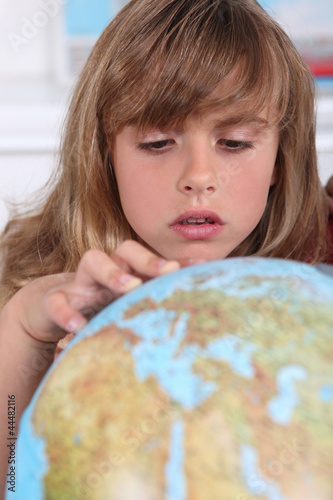 Photo: Young girl examining a globe Young girl examining a globe