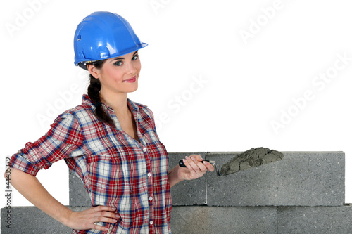 Photo: female mason applying cement female mason applying cement