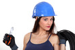 beautiful female electrician holding cutters and extension cord