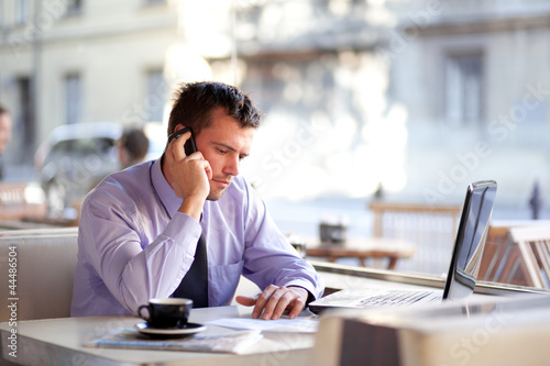 Photo: Authentic image of a businessman working in a coffee shop Authentic image of a businessman working in a coffee shop