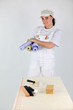 Decorator preparing to hang wallpaper