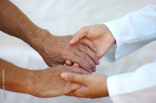 Photo: Doctora sosteniendo las manos de un anciano Doctora sosteniendo las manos de un anciano