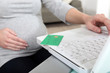 Pregnant woman sat with laptop
