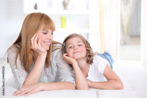 Photo: Mother and daughter laying down at home Mother and daughter laying down at home