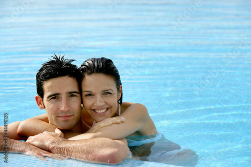 Photo: beautiful couple in a swimming pool beautiful couple in a swimming pool