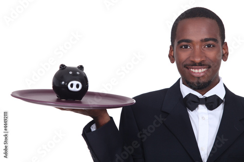 Photo: Waiter holding a piggy bank on his tray Waiter holding a piggy bank on his tray