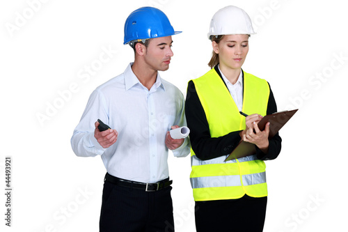 Photo: Engineer peering over a surveyor's shoulder Engineer peering over a surveyor's shoulder