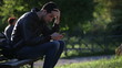 Video: Writing sms/email in a park (worried boy on a bech) Writing sms/email in a park (worried boy on a bech)