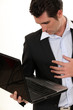 businessman holding laptop in one hand