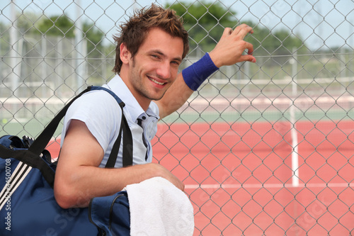 Photo: Tennis player leaning against fence Tennis player leaning against fence