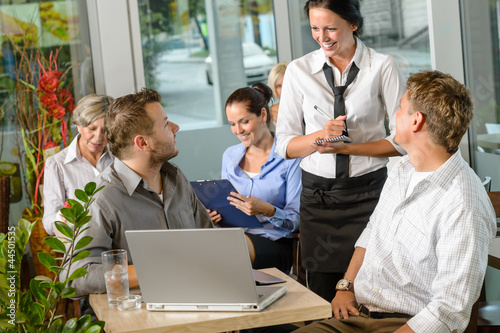 Photo: Waitress taking order from businessmen in cafe Waitress taking order from businessmen in cafe