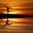 silhouette of female gymnast doing a handstand in sunset