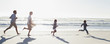 Family running on sunny beach