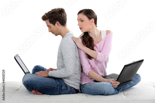 Photo: young couple of cybernauts sitting cross-legged back to back young couple of cybernauts sitting cross-legged back to back
