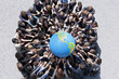 Crowd of business people in huddle reaching for globe