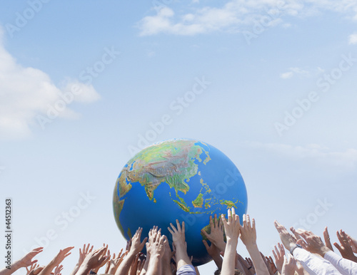 Photo: Crowd reaching for globe Crowd reaching for globe
