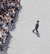 Businessman walking away from clapping crowd