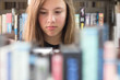 Photo: Cute teenage girl in the library surrounded by books Cute teenage girl in the library surrounded by books