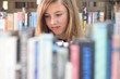 Photo: Teenage girl in the library surrounded by books Teenage girl in the library surrounded by books