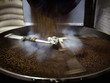 Coffee beans falling into steaming roasting machine