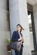 Businesswoman with briefcase in front of urban building