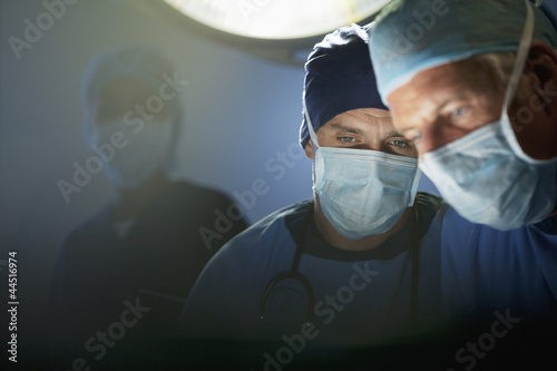 Photo: Close up of focused surgeons working in operating room Close up of focused surgeons working in operating room