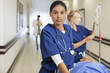 Nurses with patient on gurney in hospital corridor
