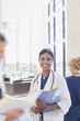 Portrait of smiling doctor holding medical records in hospital