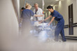 Doctors and nurses wheeling patient on gurney in hospital corridor