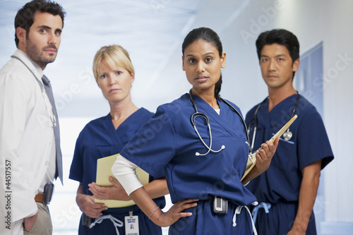 Photo: Portrait of serious doctor and nurses in hospital corridor Portrait of serious doctor and nurses in hospital corridor