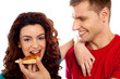 Girl enjoying pizza piece shared by her boyfriend