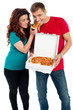 Girl sharing a pizza piece with her boyfriend