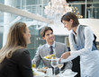 Waitress serving food to couple in restaurant
